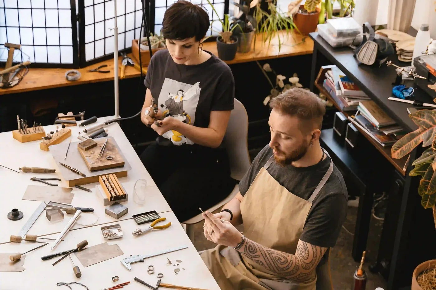 Twee edelsmeden werken aan hun werkbank in een atelier